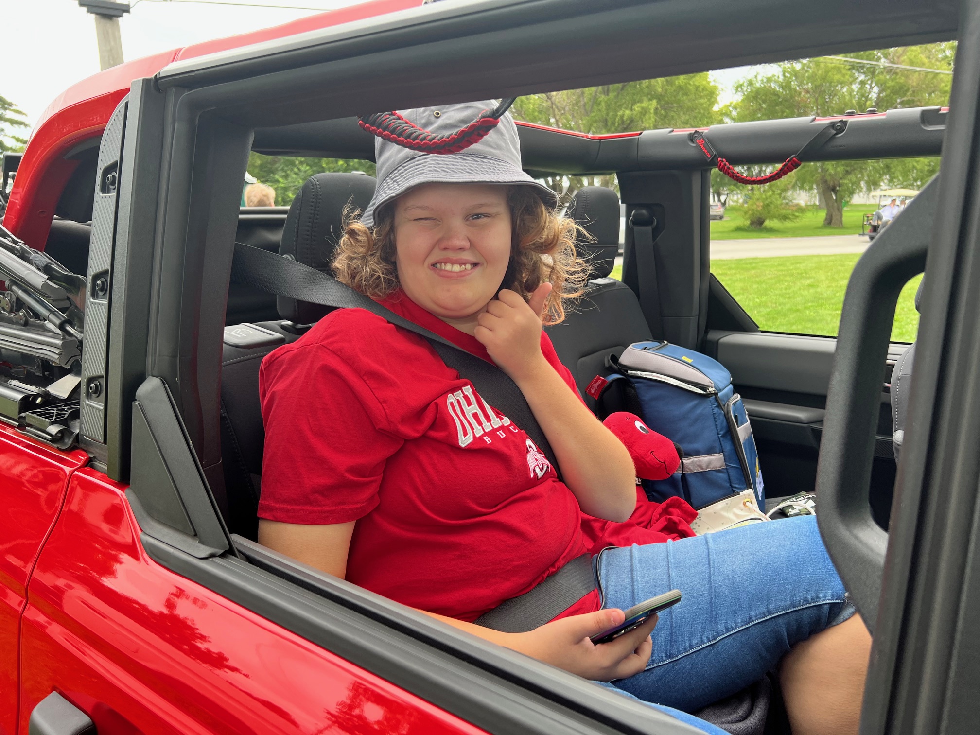 Evie in the back seat of a red Bronco.